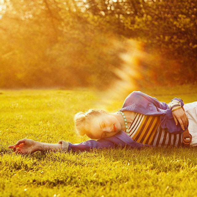 girl laying in grass during sunset