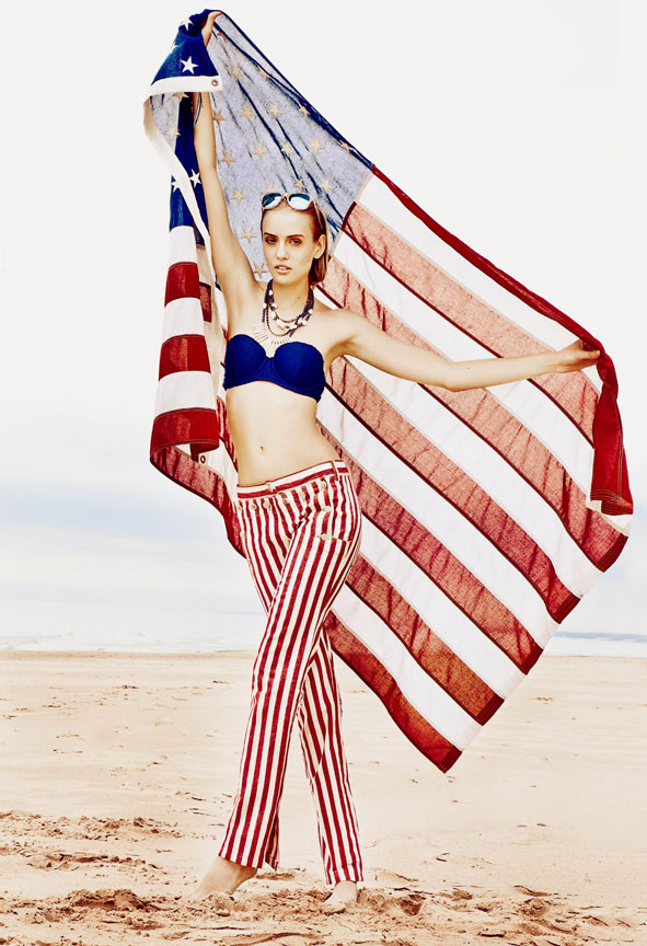 Girl holding american flag on the beach
