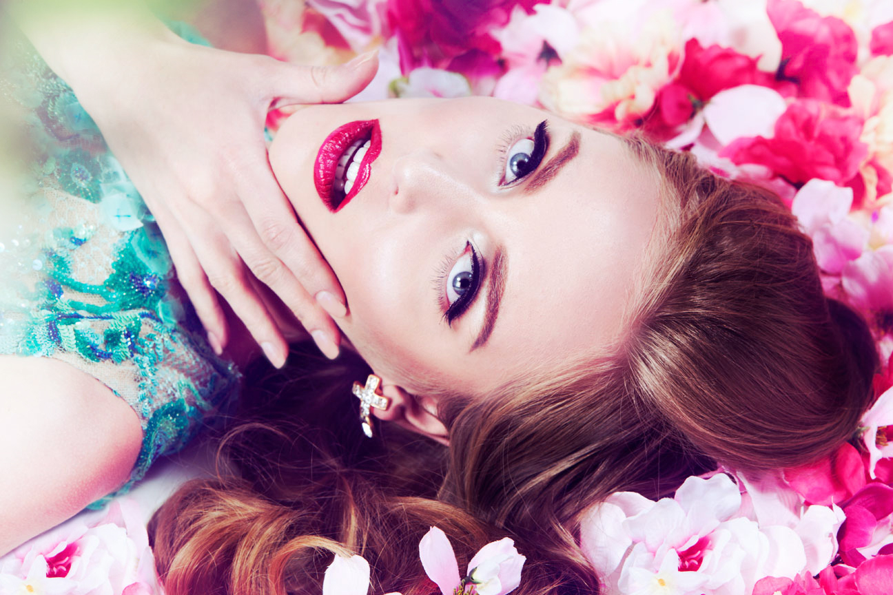 beauty image of Girl laying in pink flowers